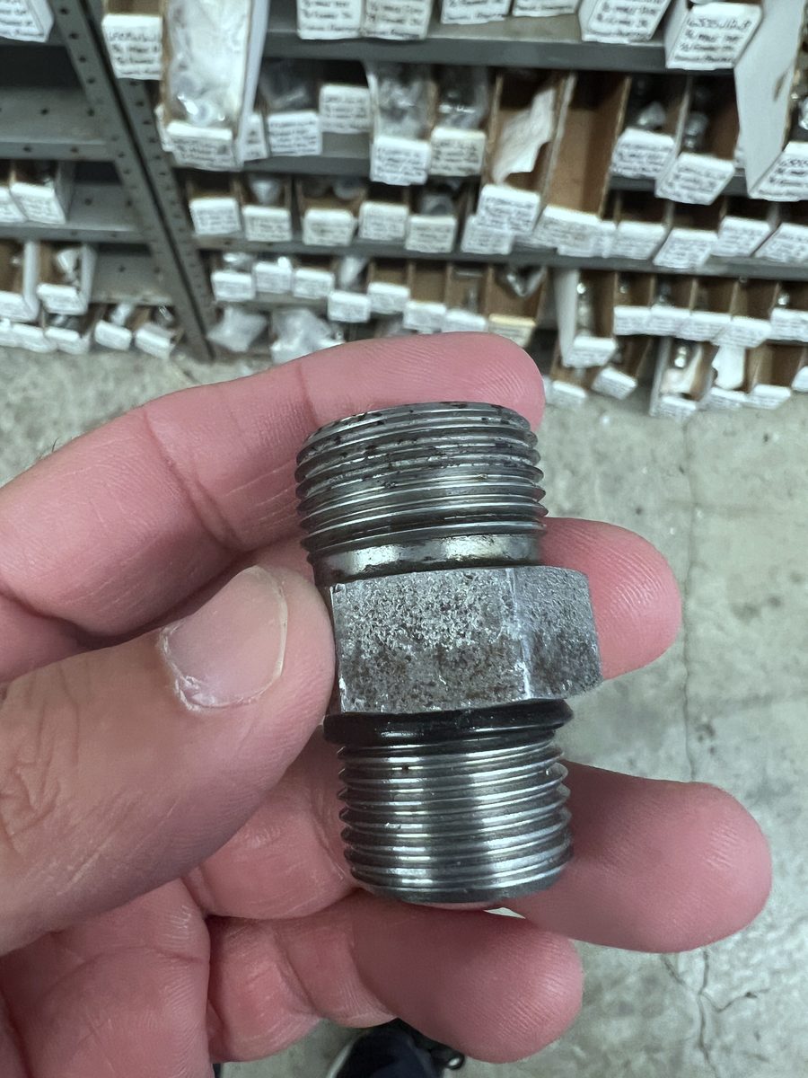 Comparing a hydraulic fitting by hand at the counter